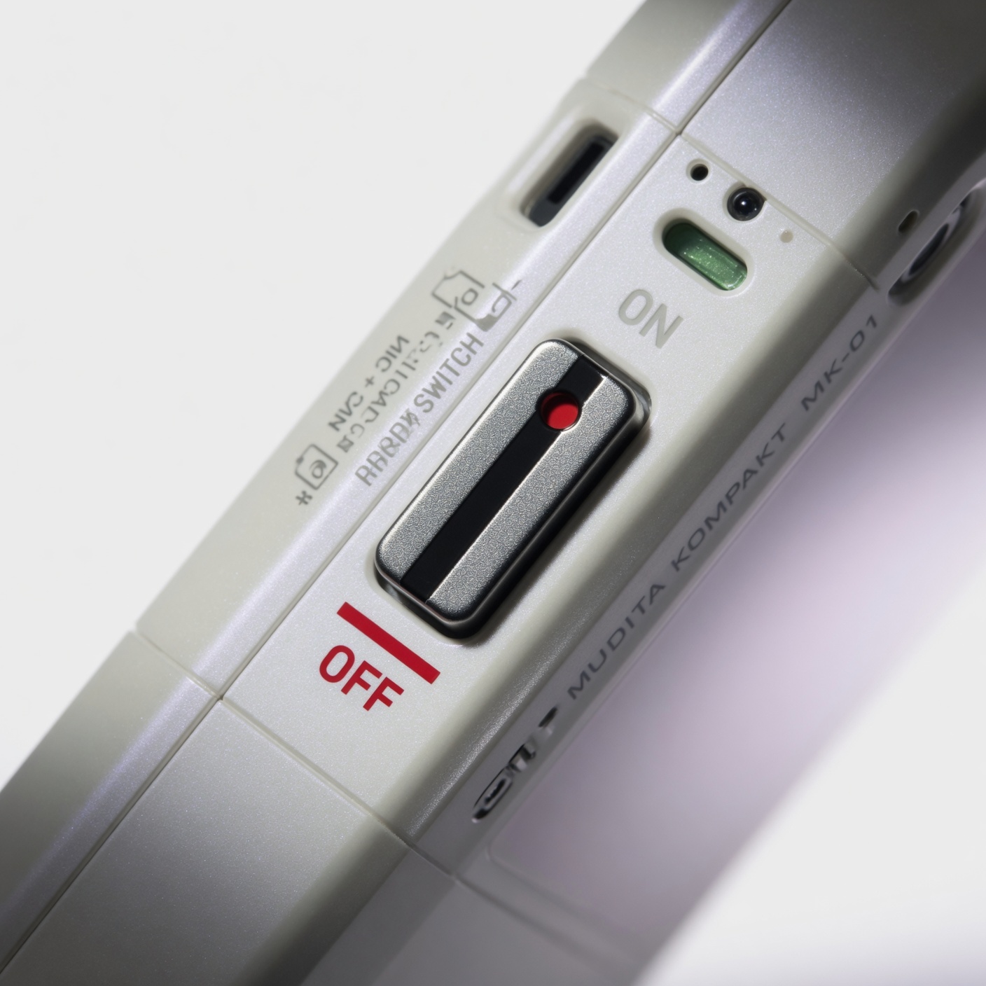 Mudita Kompakt hardware privacy switch macro — metal toggle in off position on pearl white body
