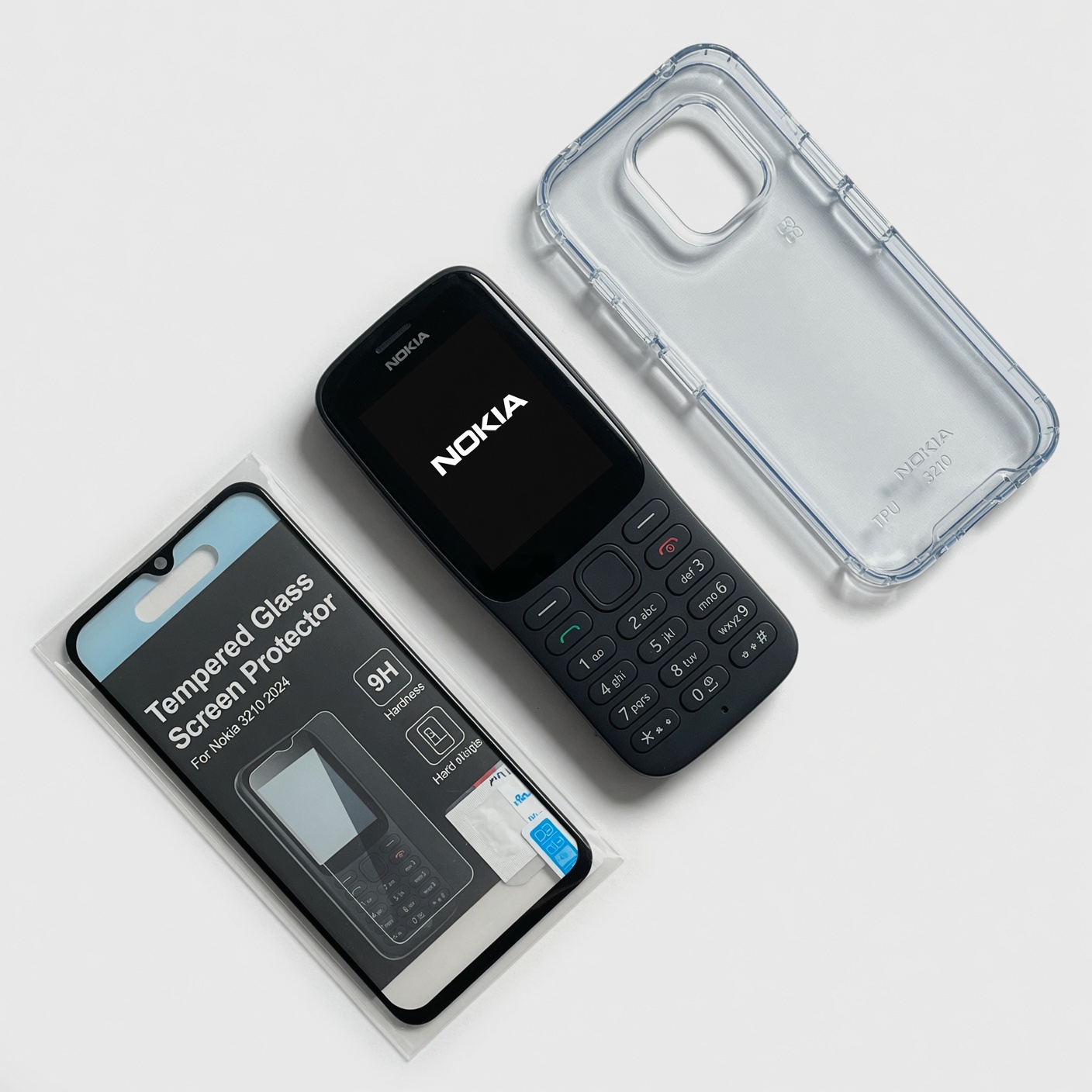 Nokia 3210 clear TPU case, tempered glass screen protector, and phone arranged flat