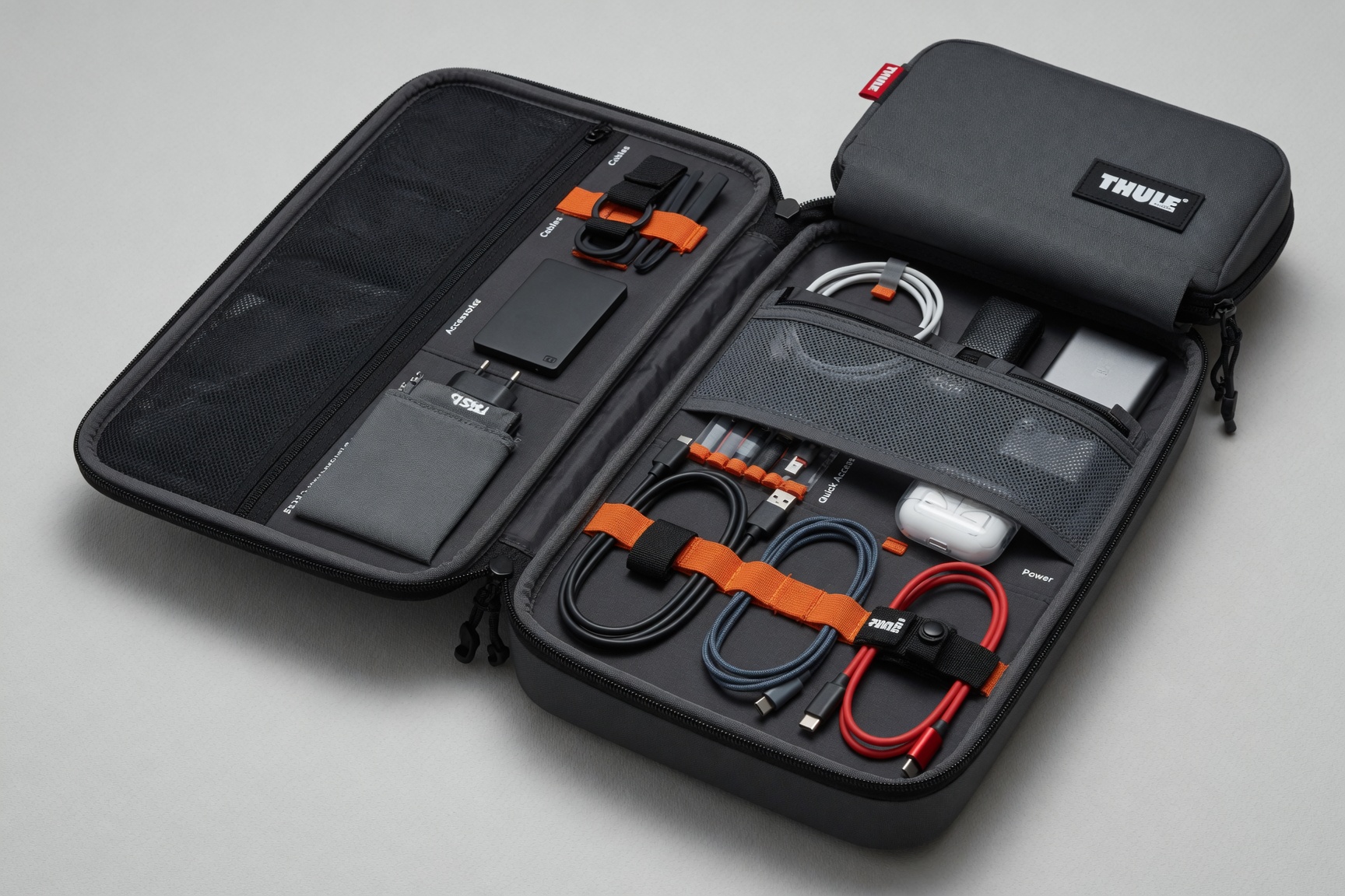 Thule Subterra PowerShuttle tech organizer open with cables and accessories organized inside, Thule logo visible